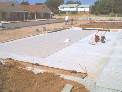 A roll of carpet is spread outside and rolled before laying it. 7/21/99